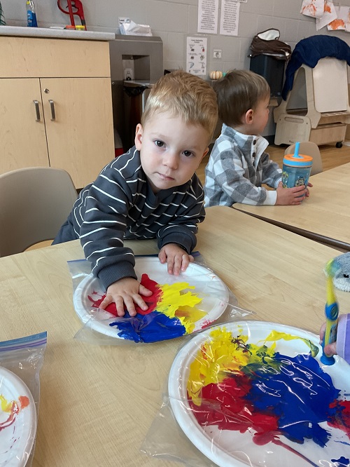 boy pressing paint with hand