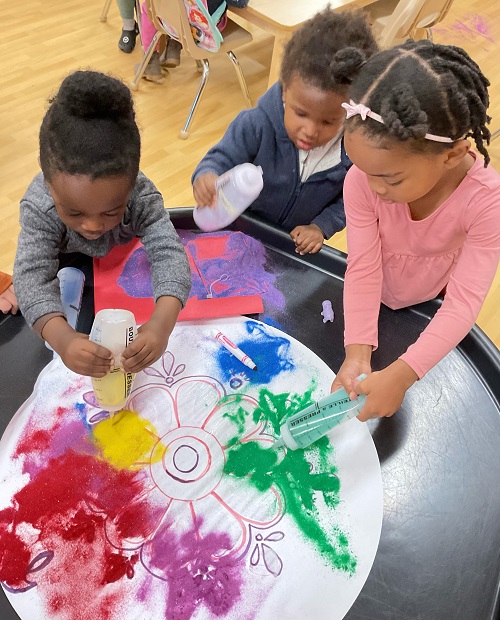 child squeezing paint bottle
