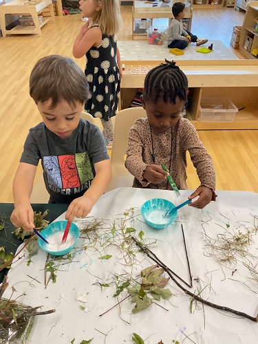 2 children glueing natrual materials