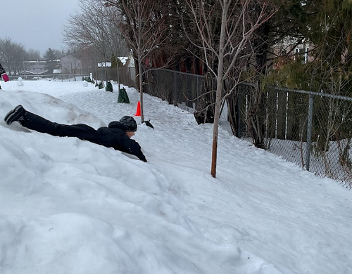 child sliding down hill