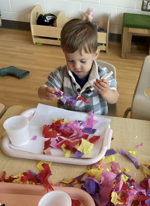 child using long tissue to make art
