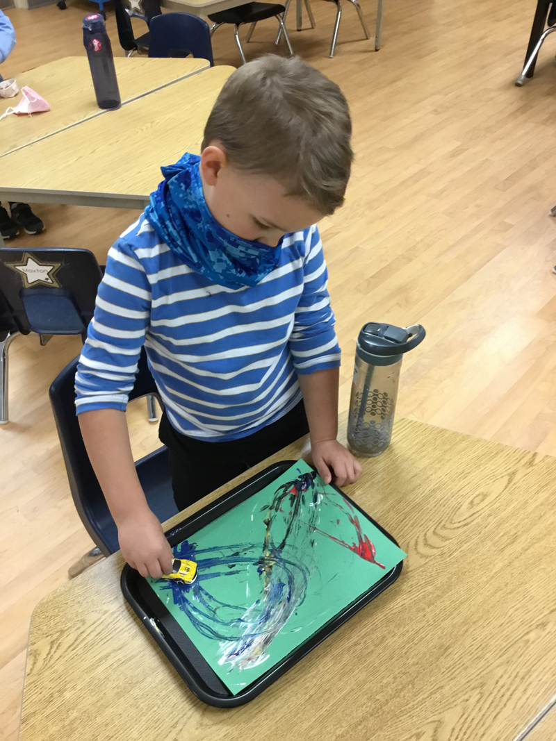 child doing pop art at a table