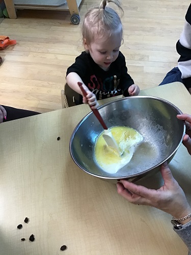A child using a spatula to stir