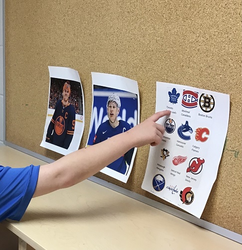 A child pointing to the symbol of their favourite Hockey team